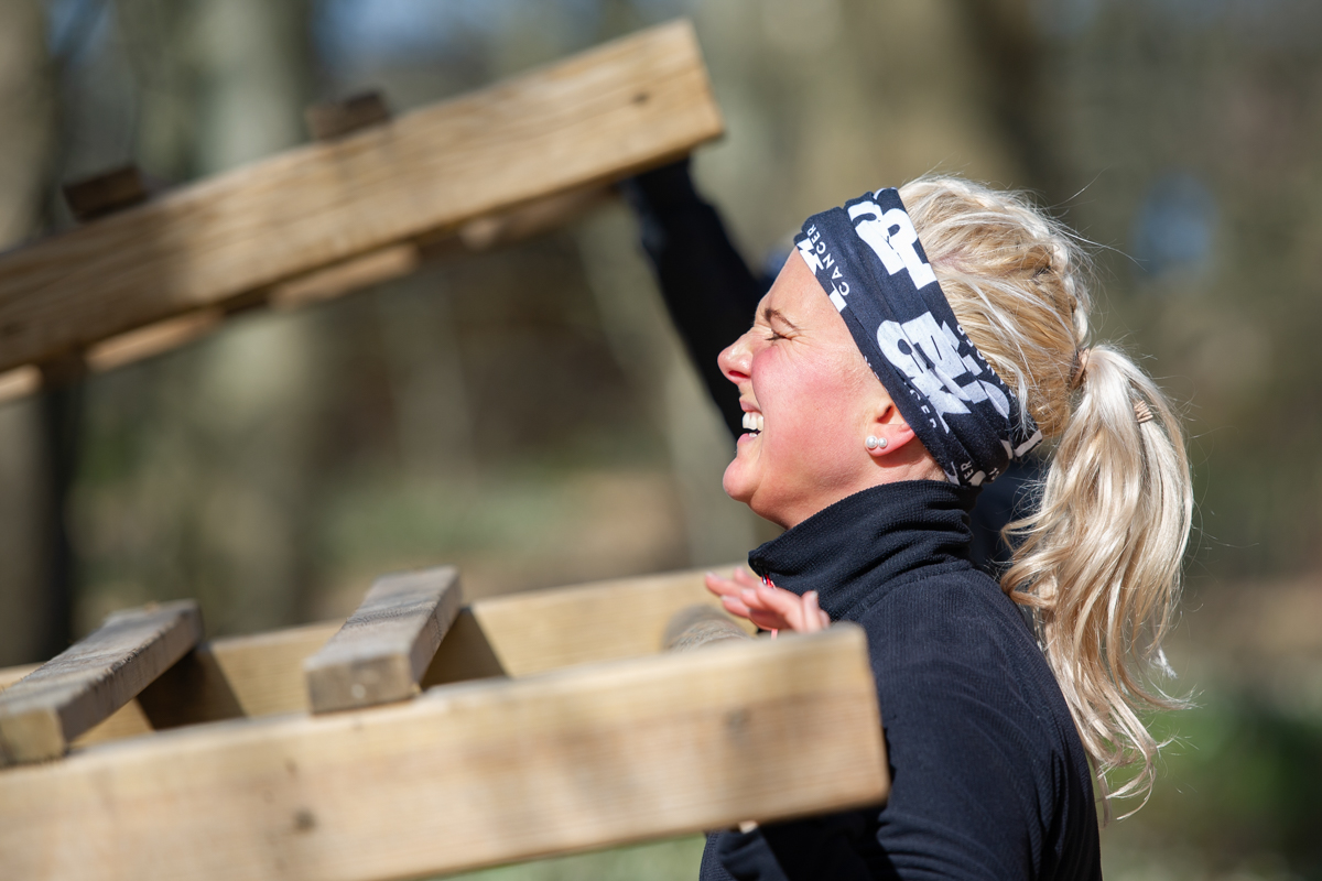 ung kvinna med hästsvans lyfter i ett utegym